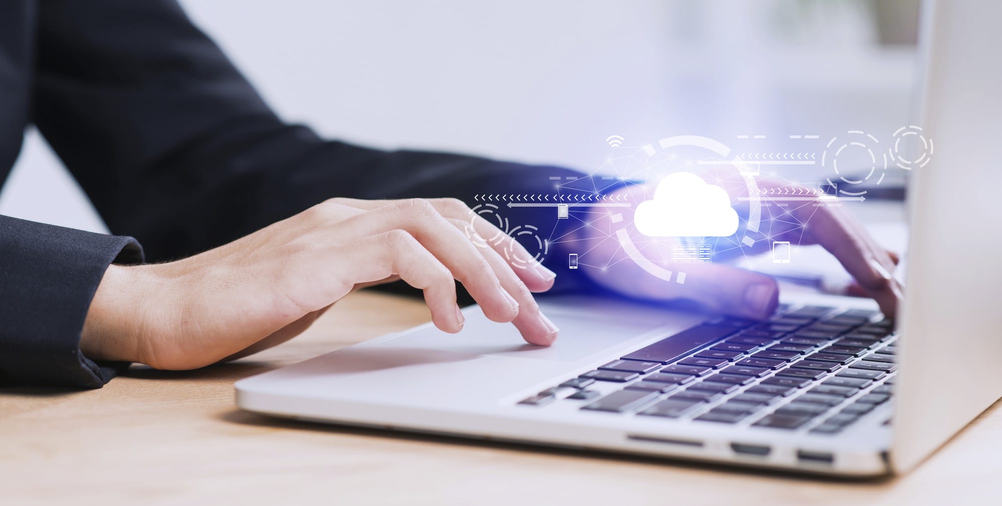 Close-up of hands on a laptop keyboard with a cloud computing network overlay representing Azure services